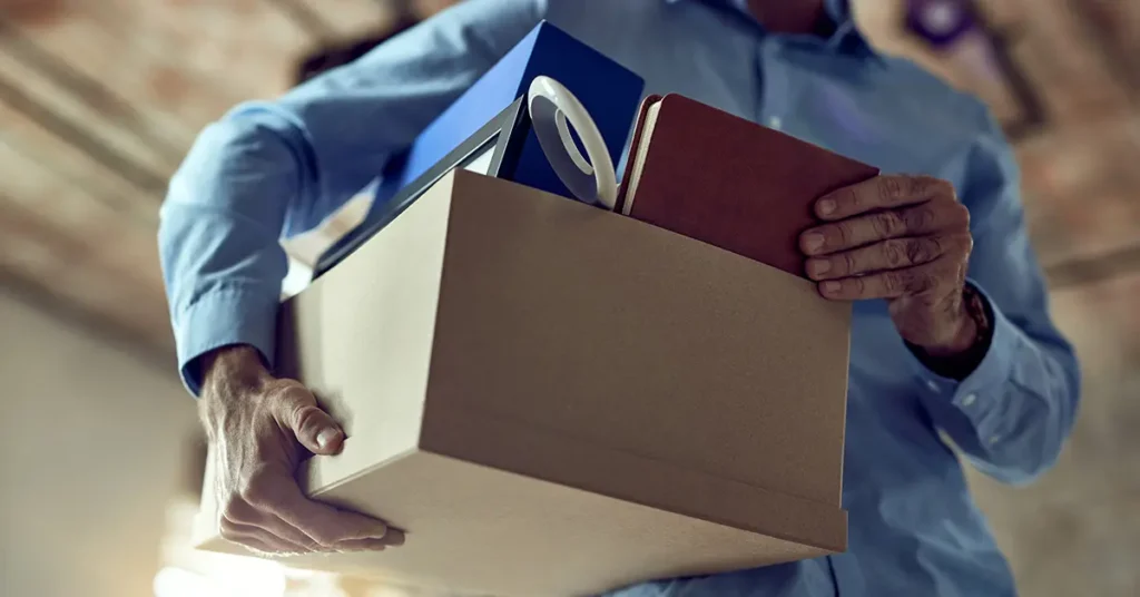Homem carregando uma caixa com os seus pertences