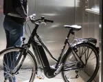 Uma moradora levando sua bike elétrica no elevador do prédio onde mora