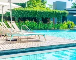 Piscina de condominio, com deck, espreguiçadeiras e guarda-sol